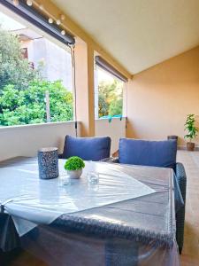 a dining room table with chairs and a window at Apartman Marijana in Pakoštane
