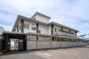 a large white building with a balcony at Beppu Ohana in Beppu