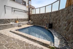 a swimming pool in the middle of a stone wall at Beppu Ohana in Beppu