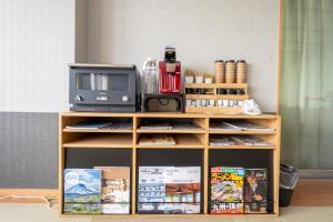 a wooden shelf with a microwave and a tv at Beppu Ohana in Beppu
