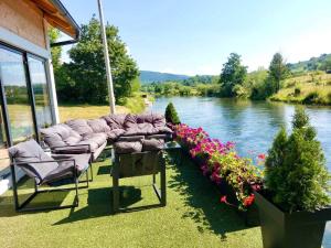 a group of chairs and flowers next to a river at Guest House Šobić in Šipovo