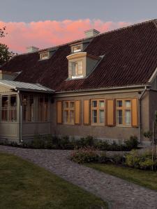 a large house with a brown roof at Ausma Hotel in Kuldīga