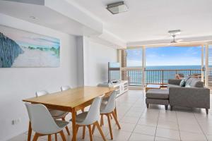 a living room with a table and chairs and a couch at Villa Seascapes in Coolum Beach