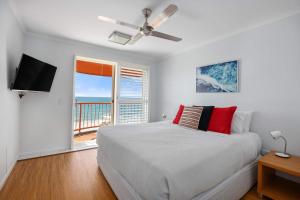 a white bedroom with a bed and a balcony at Villa Seascapes in Coolum Beach +11 photos