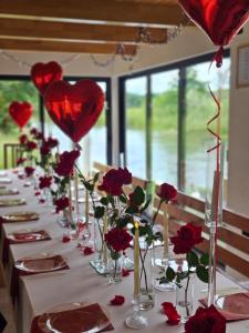 a long table with red roses and vases with hearts at Guest House Šobić in Šipovo