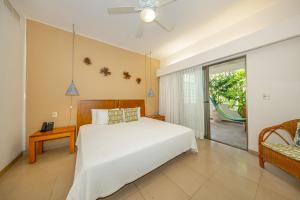 a bedroom with a white bed and a sliding glass door at Riviera Maya Suites in Playa del Carmen