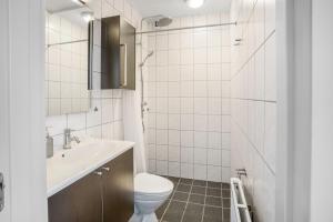 a white bathroom with a toilet and a sink at Modernized Bed & Bath in Holstebro