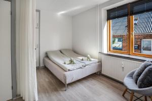 a white room with a bed and a window at Modernized Bed & Bath in Holstebro