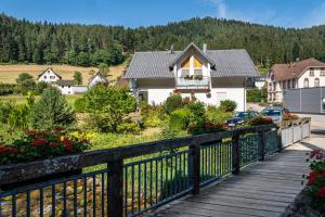 a house with a wooden bridge in front of a yard at Gästehaus Ursula in Hornberg