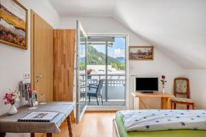 a living room with a bed and a balcony at Gästehaus Ursula in Hornberg