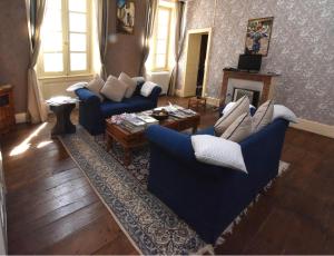 a living room with blue couches and a fireplace at Maison du Magnolia in Confolens