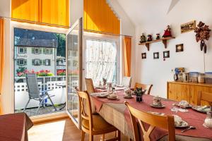 a dining room with a table and chairs and a balcony at Gästehaus Ursula in Hornberg