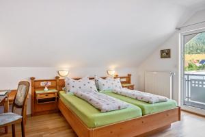 a bedroom with two beds and a desk and a window at Gästehaus Ursula in Hornberg