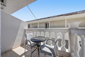 a balcony with a table and chairs on it at The Kavos Sandy Inn in Kavos