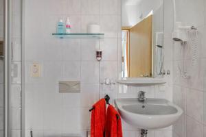 a white bathroom with a sink and a mirror at Gästehaus Ursula in Hornberg +96 photos