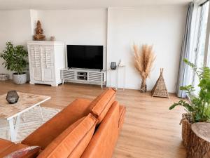 a living room with a couch and a flat screen tv at Noordwijk BB228 in Noordwijk
