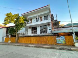 a white building with a fence in front of it at Chill Out Hostel in Boracay