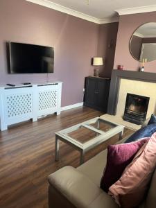 a living room with a couch and a fireplace at Sruthan na Teorainn in Carraroe