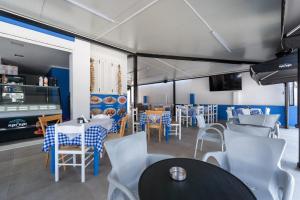 a restaurant with tables and chairs in a room at The Kavos Sandy Inn in Kavos