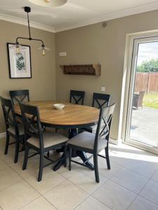 a wooden table and chairs in a room with a window at Sruthan na Teorainn in Carraroe +8 photos