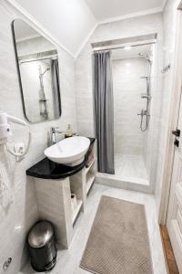 a white bathroom with a sink and a shower at Вілла Смерекова хата in Kelechin