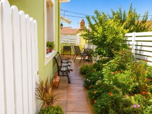 a patio with chairs and plants and a fence at Granny's Home in Roussopoúlion