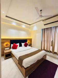 a bedroom with a large bed with red pillows at Pancharatna Regency in Chinchwad +37 photos