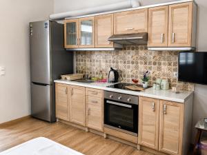 a kitchen with wooden cabinets and a stainless steel refrigerator at Granny's Home in Roussopoúlion