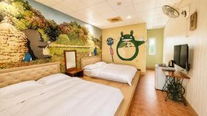 a room with two beds and a painting on the wall at Family Pottery in Hengchun South Gate +15 photos