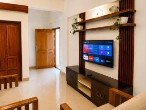 a living room with a flat screen tv on a wall at Serene Padmanabham Premium Luxury Apartments Near Sree Padmanabhaswamy Temple in Trivandrum