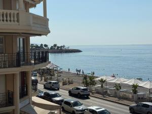 a street with cars parked next to the beach at Victoria Beach Front de Mer Luxury Apartment in Menton