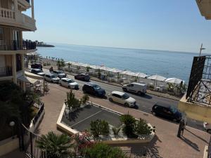 a parking lot with cars parked next to the ocean at Victoria Beach Front de Mer Luxury Apartment in Menton