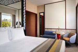 a hotel room with a bed and a table at Avani Avenida Liberdade Lisbon Hotel in Lisbon