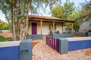 a house with a fence in front of it at Gondwana Damara Mopane Lodge in Mopane Pos