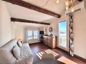 a living room with a couch and a large window at L'étincelle de Camargue, Plage et centre à pied in Saintes-Maries-de-la-Mer