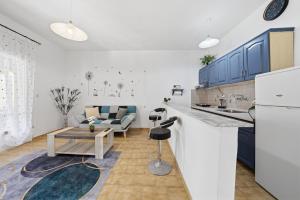 a kitchen and living room with blue cabinets at Mermaids By The Sea in Mesongi