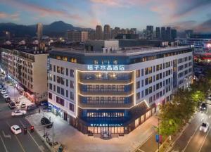 a large white building with writing on it in a city at Orange Crystal Hotel Ningbo Ninghai in Ninghai