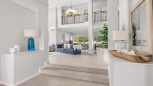 a living room with white walls and a blue couch at Vintage Lodge in Pokolbin