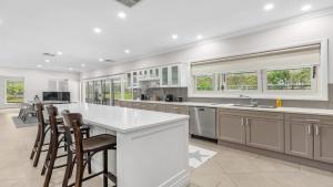 a kitchen with a white counter and some chairs at Vintage Lodge in Pokolbin