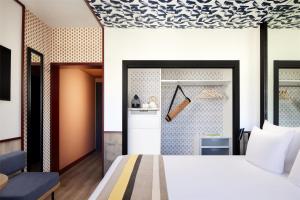 a bedroom with a bed and a tile wall at Avani Avenida Liberdade Lisbon Hotel in Lisbon