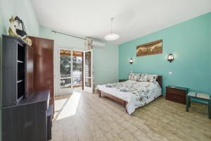a bedroom with a bed and a tv in it at Mermaids By The Sea in Mesongi