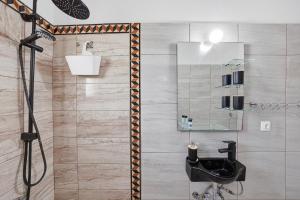 a bathroom with a shower with a black sink at Mermaids By The Sea in Mesongi +31 photos