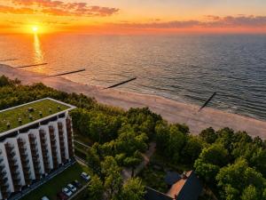 an aerial view of a building and the ocean at sunset at Pinea Premium 4YOU Baseny i Sauna w cenie !!! in Pobierowo