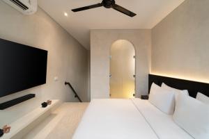 a bedroom with a large bed with a ceiling fan at The Arc House Canggu in Canggu +44 photos