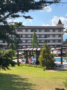 a hotel with a swimming pool in front of a building at Hotel Sevtopolis Medical & SPA in Pavel Banya