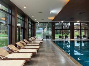 a swimming pool with lounge chairs in a building at Hotel Sevtopolis Medical & SPA in Pavel Banya