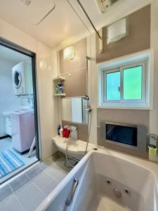 a bathroom with a large tub and a sink at Takumisou1 in Kiso
