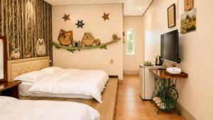 a hotel room with two beds and a tv at Family Pottery in Hengchun South Gate