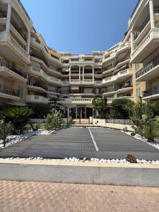an empty parking lot in front of a large building at Victoria Beach Front de Mer Luxury Apartment in Menton