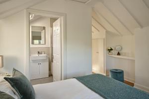 a white bedroom with a bed and a sink at South Lodge at Pudleston Court in Hatfield +14 photos
